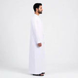 Qamis blanc saoudien premium pour homme, vêtement traditionnel élégant, porté par un homme dans une image.